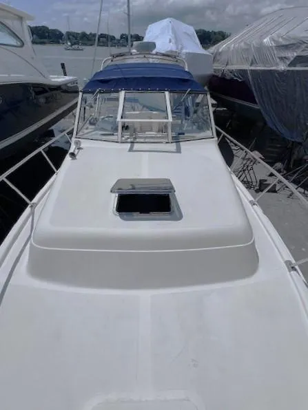 Slide: The Image of 2004 Mainship 30 Pilot Rum Runner boat docked, featuring a sleek white deck and blue canopy. - 11