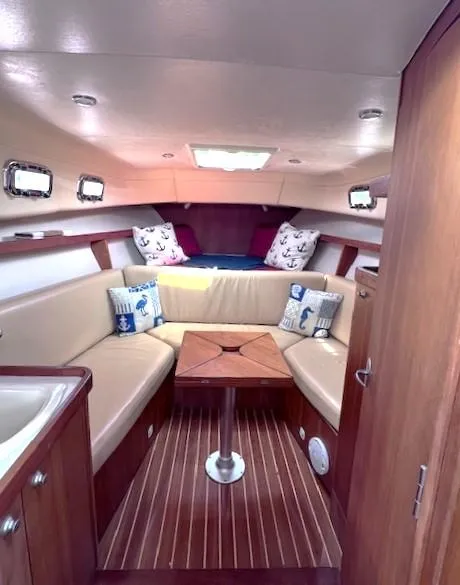 Slide: The Image of 2004 Mainship 30 Pilot Rum Runner cabin with cozy seating and nautical decor. - 13