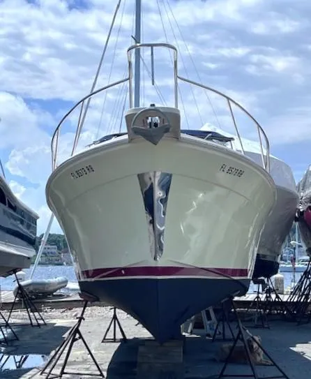 Slide: The Image of 2004 Mainship 30 Pilot Rum Runner boat on dry dock under a partly cloudy sky. - 5
