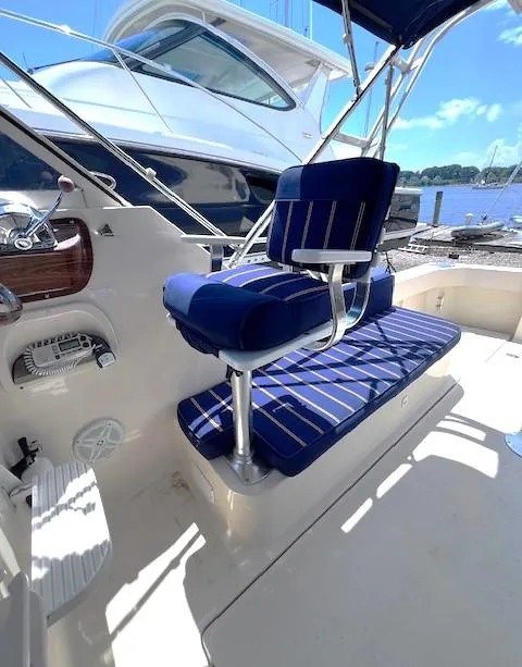 Slide: The Image of 2004 Mainship 30 Pilot Rum Runner boat with blue seating, docked by the water. - 7