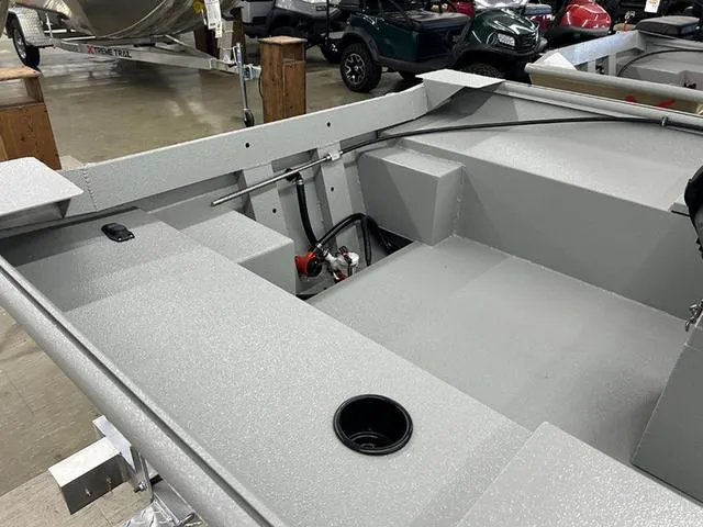 Slide: The Image of 2025 XTREME BOATS River Skiff 1548SS interior, showcasing seating and storage features in a showroom. - 4
