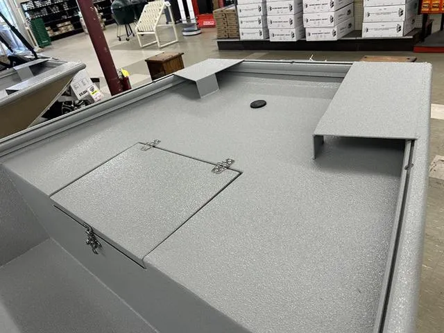 Slide: The Image of 2025 XTREME BOATS River Skiff 1548SS interior with storage compartments, displayed in a showroom. - 7