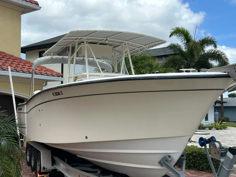 Slide: The Image of 2002 Grady-White 306 Bimini boat on trailer, parked near tropical home. - 1