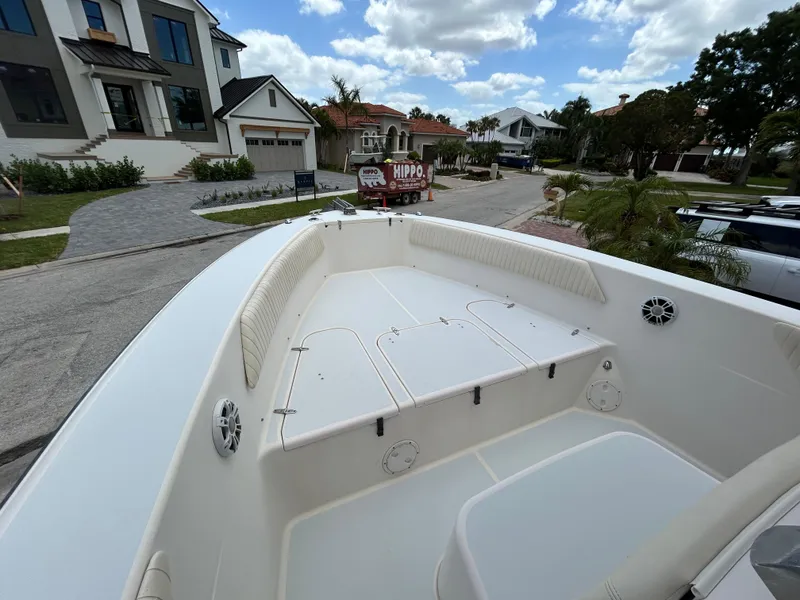 Slide: The Image of 2002 Grady-White 306 Bimini boat, spacious deck, residential street background, partly cloudy sky. - 10