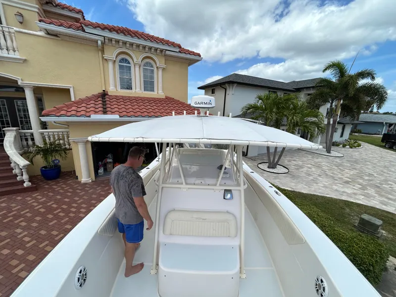 Slide: The Image of Man on 2002 Grady-White 306 Bimini boat near a house with palm trees. - 14
