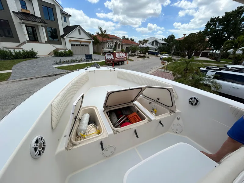 Slide: The Image of 2002 Grady-White 306 Bimini boat with open storage compartments, docked in a residential area. - 16