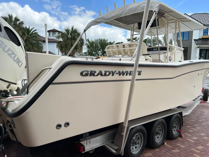 Slide: The Image of 2002 Grady-White 306 Bimini boat on trailer, featuring a sleek design and canopy. - 2