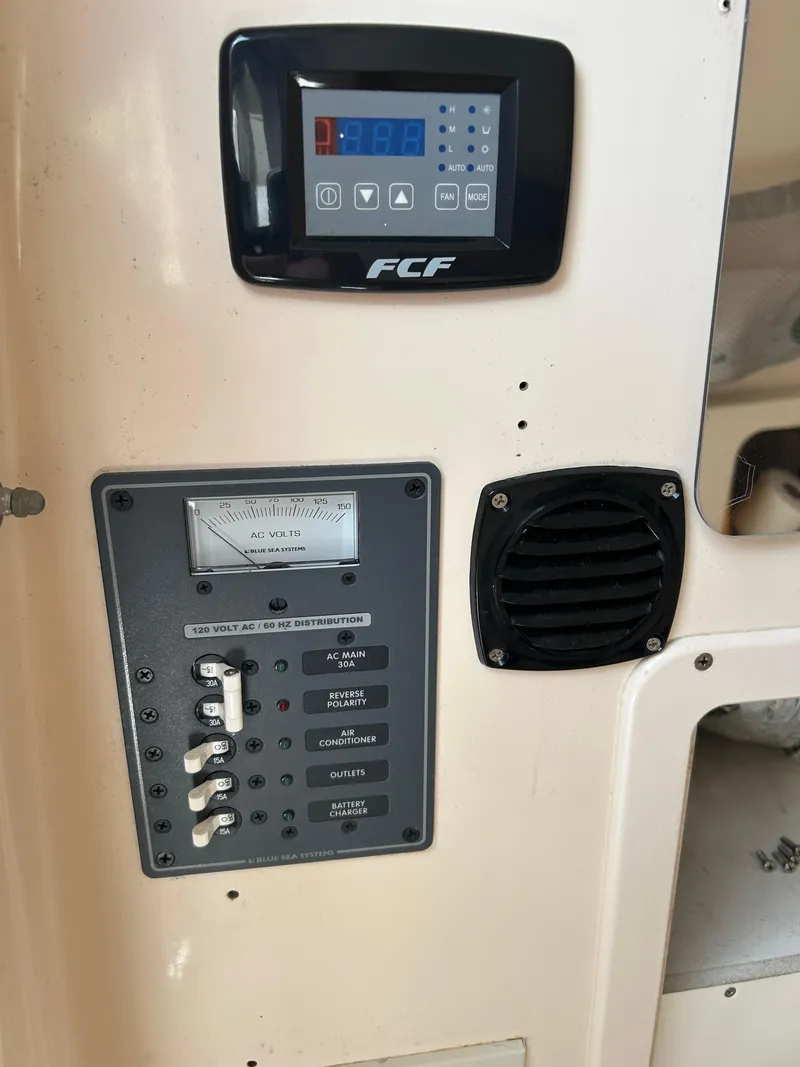 Slide: The Image of Control panel of a 2002 Grady-White 306 Bimini boat, featuring switches and a digital display. - 20