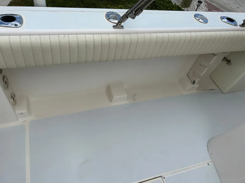 Slide: The Image of 2002 Grady-White 306 Bimini boat interior, featuring rod holders and cushioned side panel. - 28