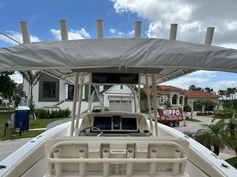 Slide: The Image of 2002 Grady-White 306 Bimini boat with canopy, docked near luxury homes. - 8