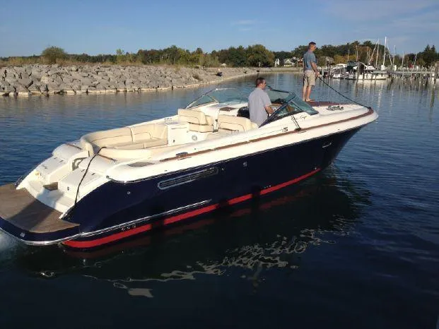 The Image of 2007 Chris-Craft Corsair 36 boat on calm water near a rocky shoreline. - 0
