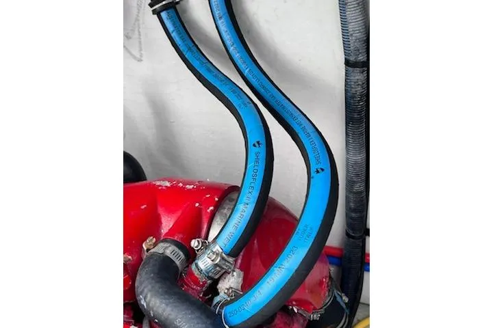 Slide: The Image of Engine hoses in a 2007 Chris-Craft Corsair 36 boat, featuring blue and black tubing. - 23