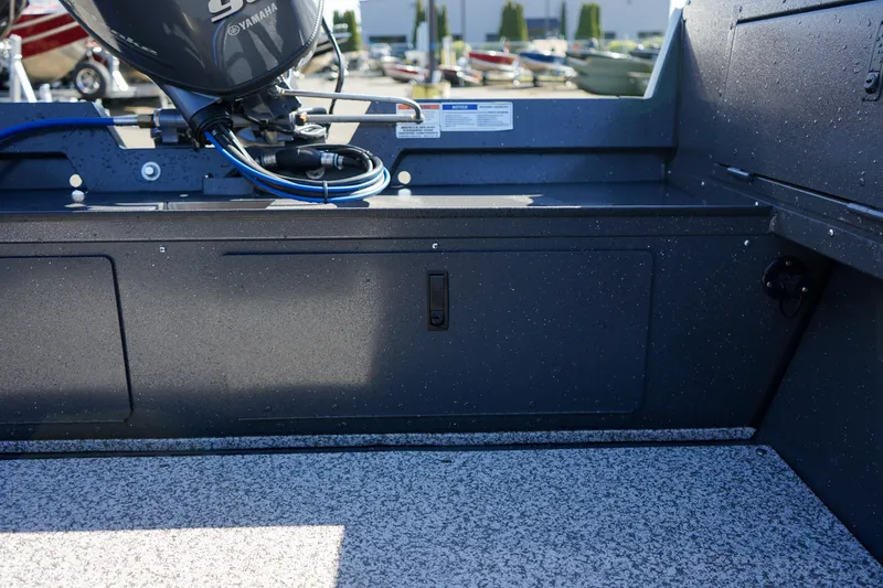 Slide: The Image of 2025 Alumaweld Adventurer 20 boat interior with motor, showcasing storage and seating area. - 12