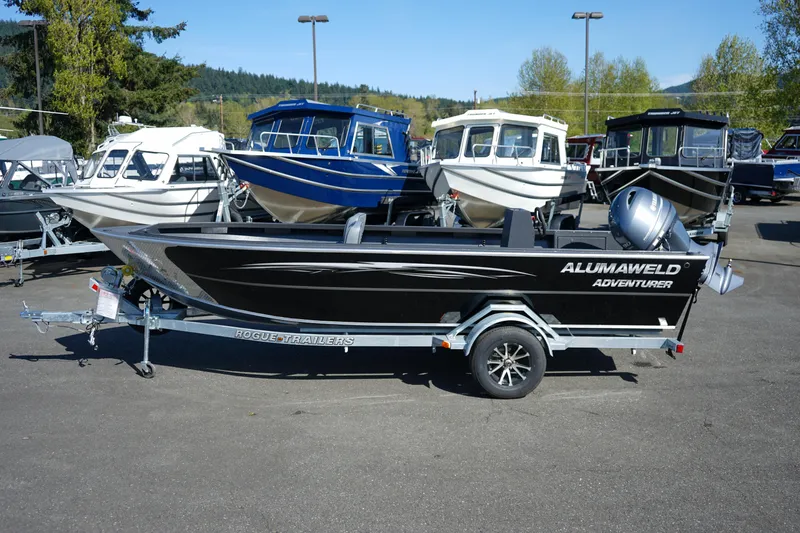 Slide: The Image of 2025 Alumaweld Adventurer 20 boat on trailer, parked in a marina with other boats. - 3