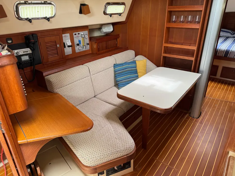 Slide: The Image of Cozy interior of 2002 Island Packet 380 sailboat with cushioned seating and wooden table. - 10