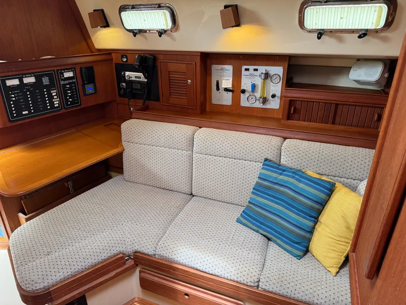 Slide: The Image of Cozy interior of 2002 Island Packet 380 sailboat with cushioned seating and control panels. - 21