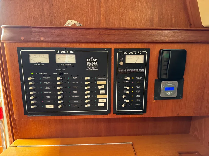 Slide: The Image of Electrical control panel on a 2002 Island Packet 380 yacht, featuring 12V DC and 120V AC systems. - 23