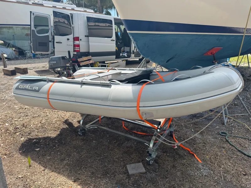 Slide: The Image of Inflatable dinghy secured on trailer beside Island Packet 380 sailboat, 2002 model. - 27