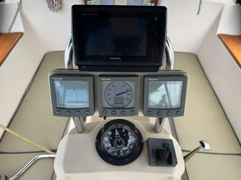 Slide: The Image of Cockpit instruments of a 2002 Island Packet 380 sailboat, featuring Raymarine displays and a compass. - 34