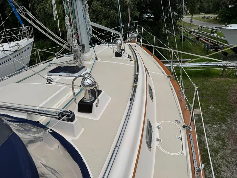 Slide: The Image of 2002 Island Packet 380 sailboat deck with rigging and hatches, docked on land. - 36