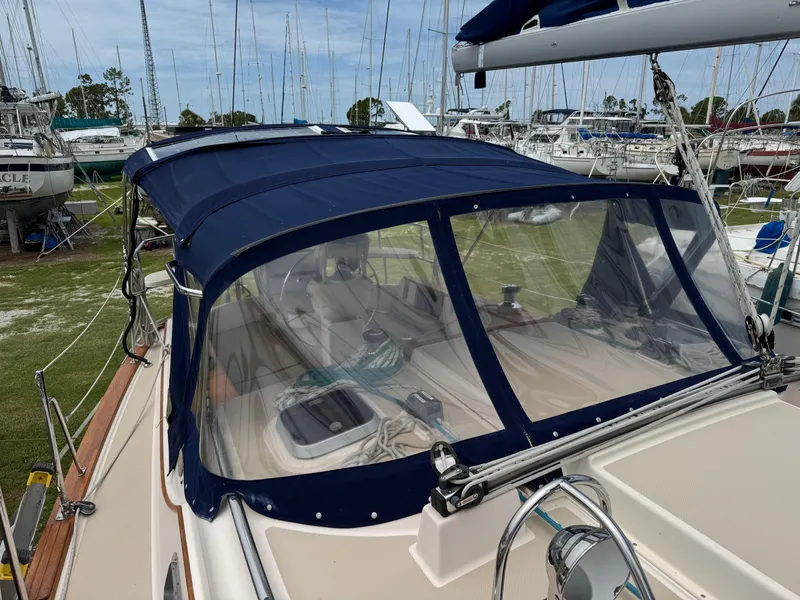 Slide: The Image of 2002 Island Packet 380 sailboat with blue canopy, docked in a marina. - 37