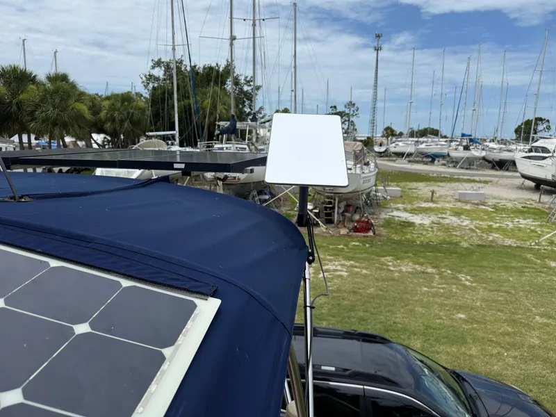 Slide: The Image of 2002 Island Packet 380 with solar panel and satellite dish in a marina setting. - 40