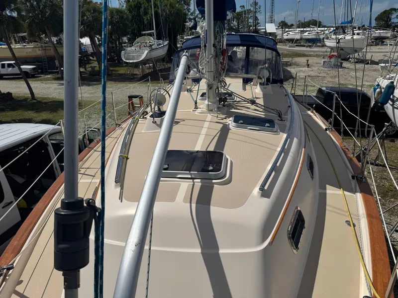 Slide: The Image of Island Packet 380 sailboat deck, 2002 model, docked in a marina with surrounding boats. - 6