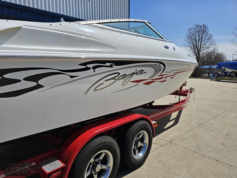 Slide: The Image of 2004 Baja 275 boat on red trailer, sleek design with custom graphics. - 11