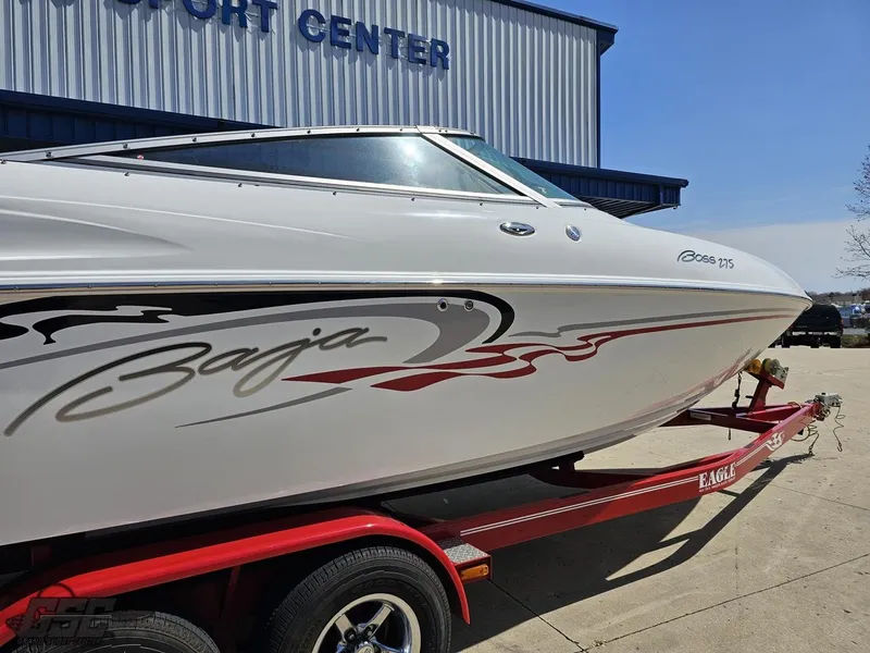 Slide: The Image of 2004 Baja 275 speedboat on a red trailer outside a marine center. - 12