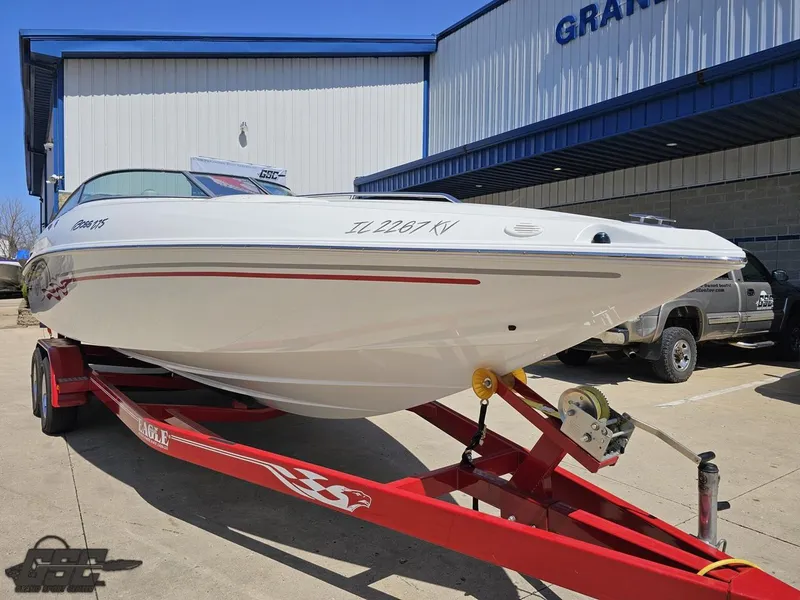 Slide: The Image of 2004 Baja 275 boat on red trailer outside a building. - 15