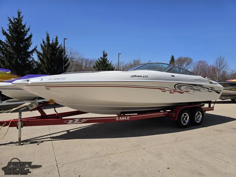 Slide: The Image of 2004 Baja 275 speedboat on a red trailer, parked outdoors. - 18