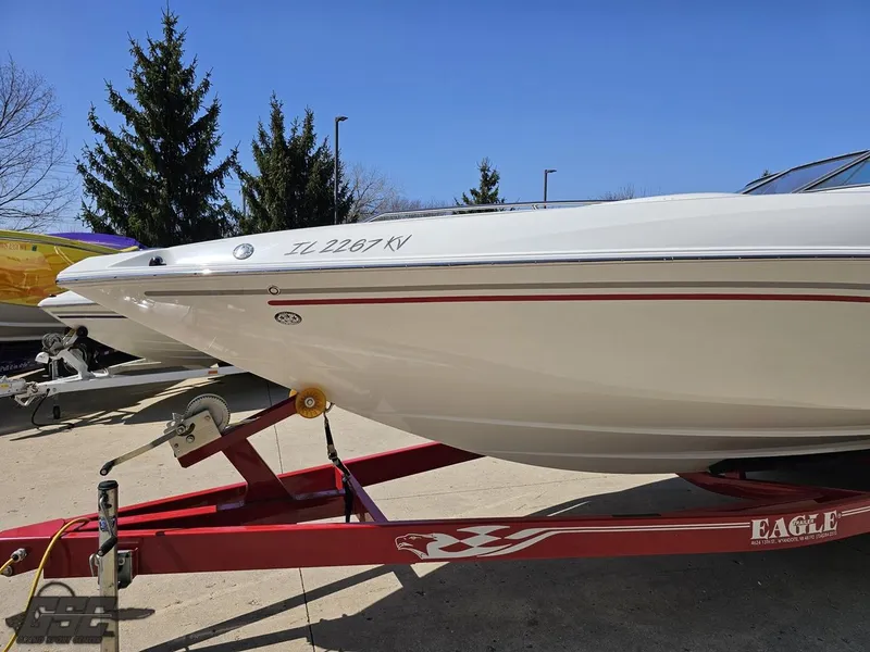 Slide: The Image of 2004 Baja 275 boat on red trailer, parked outdoors. - 19