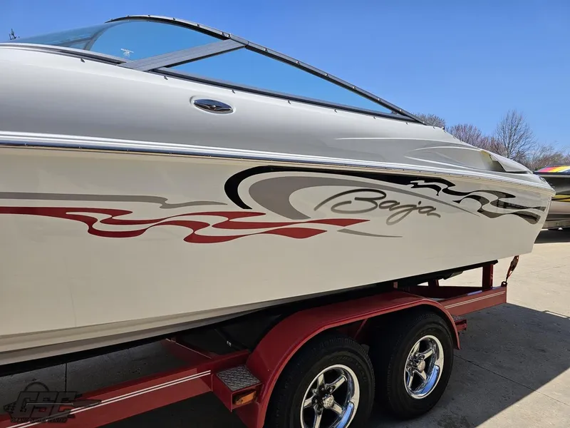 Slide: The Image of 2004 Baja 275 boat on red trailer, featuring sleek design and stylish graphics. - 21