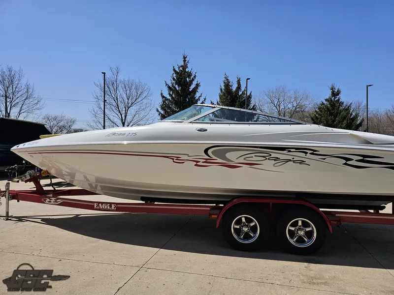 Slide: The Image of 2004 Baja 275 speedboat on trailer, sleek design, parked outdoors under clear blue sky. - 22