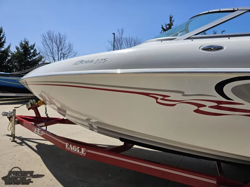 Slide: The Image of 2004 Baja 275 boat on a red Eagle trailer, parked outdoors. - 23