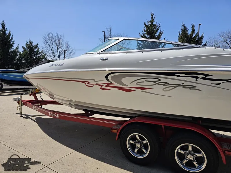 Slide: The Image of 2004 Baja 275 boat on trailer, sleek design, parked outdoors. - 24