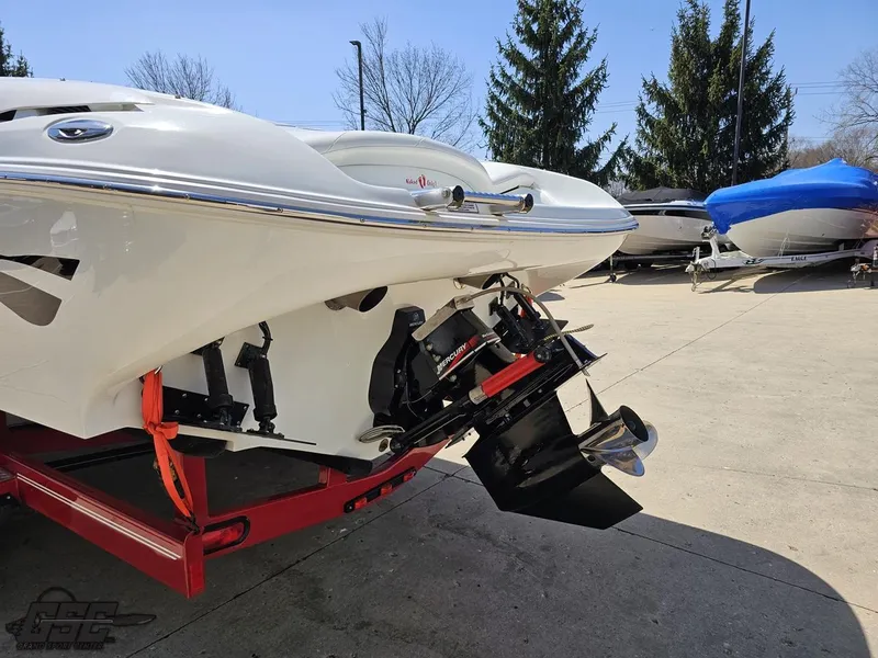 Slide: The Image of 2004 Baja 275 boat on trailer, rear view showing outboard motor, parked outdoors. - 27
