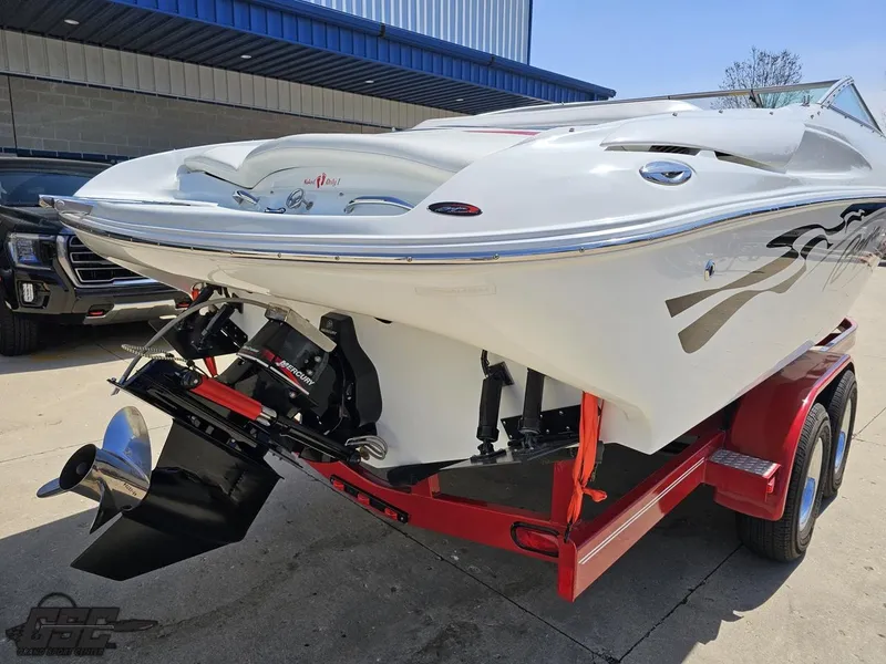 Slide: The Image of 2004 Baja 275 boat on red trailer, parked outdoors near a building. - 30