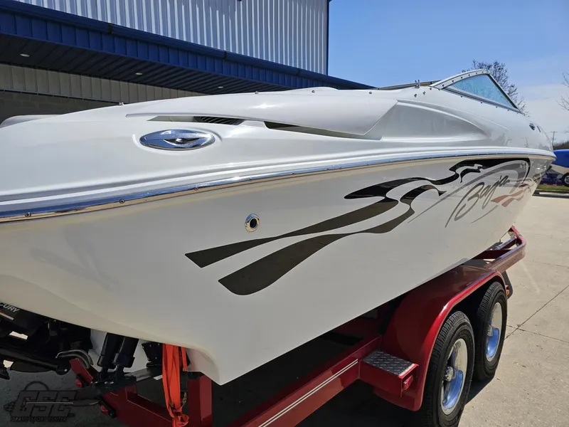 Slide: The Image of 2004 Baja 275 boat on red trailer, sleek design with black graphics. - 31