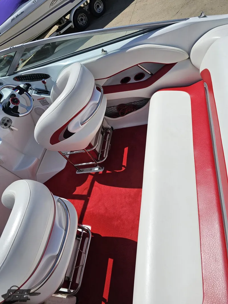Slide: The Image of 2004 Baja 275 boat interior with red and white seating and steering wheel. - 45