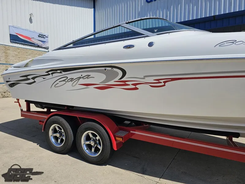 Slide: The Image of 2004 Baja 275 boat on red trailer, sleek design with bold graphics. - 8