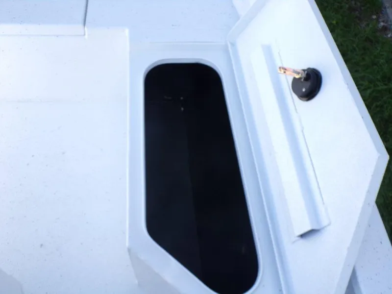 Slide: The Image of Open storage compartment on 2025 Xpress H20BAY boat, featuring a sleek white design. - 12