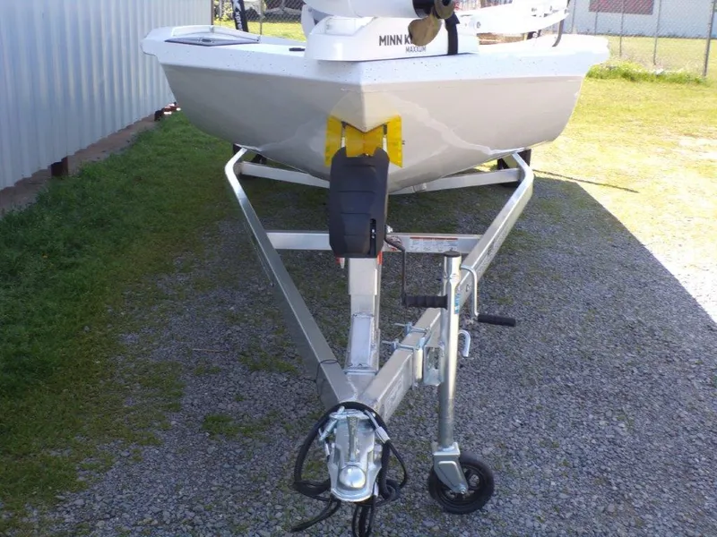 Slide: The Image of 2025 Xpress H20BAY boat on trailer, parked on gravel near a building. - 16