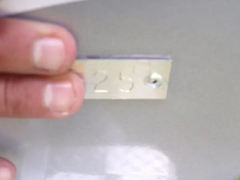 Slide: The Image of Close-up of a hand holding a metal tag with the number "258" on a 2025 Xpress H20BAY. - 18