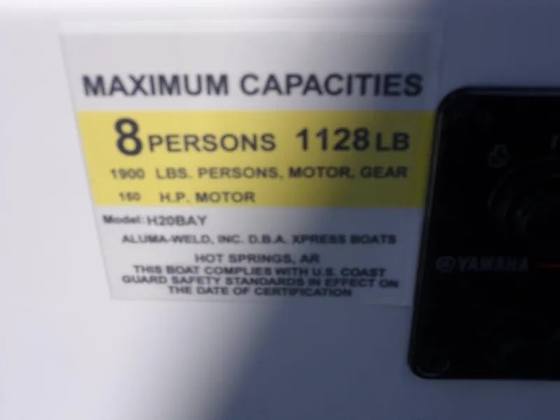 Slide: The Image of 2025 Xpress H20BAY boat capacity label: 8 persons, 1128 lbs, 150 HP motor. - 5