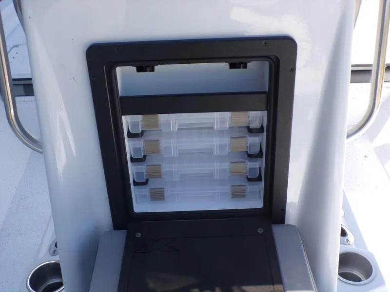 Slide: The Image of 2025 Xpress H20BAY boat storage compartment with organized tackle boxes. - 7
