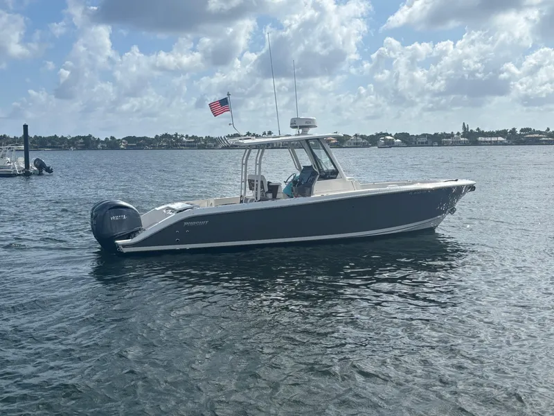 The Image of 2022 Pursuit S 288 boat on calm water with American flag, under cloudy sky. - 0