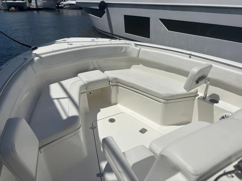 Slide: The Image of 2022 Pursuit S 288 boat interior with white seating, docked at marina. - 11
