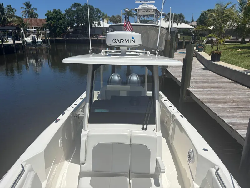 Slide: The Image of 2022 Pursuit S 288 boat docked, featuring Garmin equipment, sunny day, waterfront setting. - 13