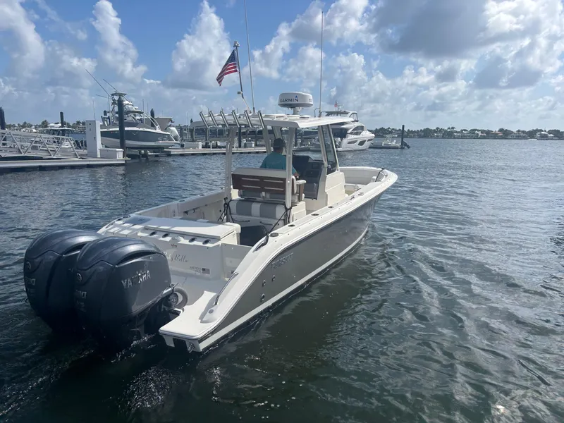 Slide: The Image of 2022 Pursuit S 288 boat with dual Yamaha engines docked in a marina. - 2
